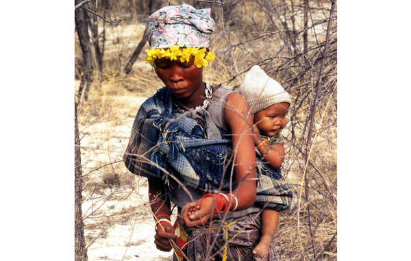 Une mère bushman et son enfant cueillent des baies dans la réserve du Kalahari central.