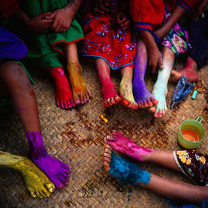 Ragazzi e ragazze huicol del Messico si colorano i piedi con gesso e colori in polvere.