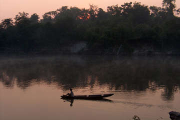 Pirahã man paddles by sundown on the Maici river. The tribe are at risk from plans for the Madeira River dams.
