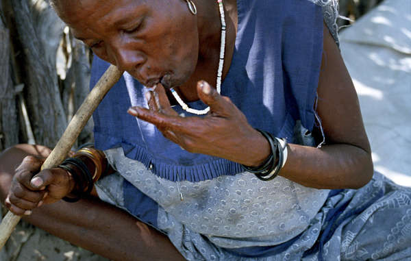 A Bushman woman chews the flesh of a melon for it's moisture in the village of Metsiameneng. Melons are cultivated by the Bushmen and provide a source of water, especially useful during the years that the government denied them access to boreholes.
