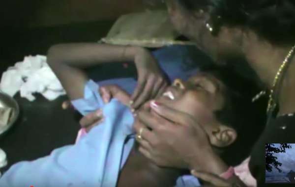 Akash Orang is comforted by his mother after being shot by a park guard. He is now severely disabled.