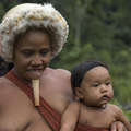 Zo'é women carrying young babies in slings which they make from plant fibres or cotton. &copy; <span class="caps">FENAMAD</span>