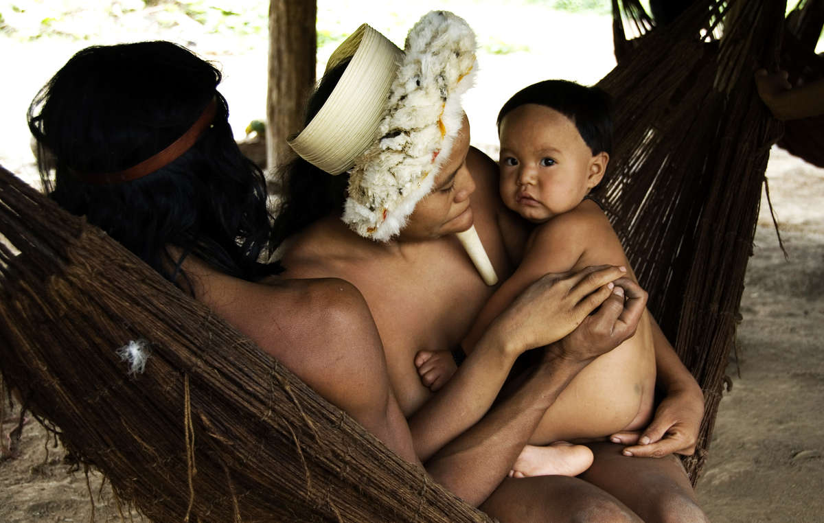 A Zo'é family relaxes in a hammock they made from Brazil nut fibres.
