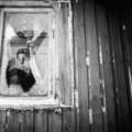 A young Innu looks out from one of the government buildings they have been forced to settle in, Canada. &copy; Adam Hinton/Survival