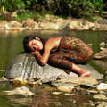 Penan girl, Diana, rests by the river, Malaysia. &copy; Sofia Yu/Survival