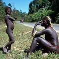 Un niño y un hombre jarawa al lado de la carretera _Andaman Trunk Road_. &copy; Salomé
