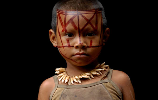 Un niño nukak con un collar de dientes de mono. 