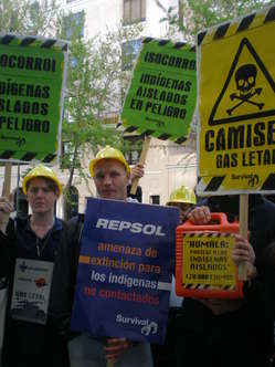 Manifestantes en Madrid con pancartas y cascos de obra denuncian las consecuencias letales de Camisea para los indígenas aislados.