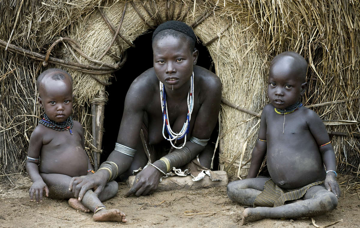 The Karo (or Kara), with a population of about 1000 - 1500 live on the east banks of the Omo River in south Ethiopia. Here, a Karo mother sits with her children.