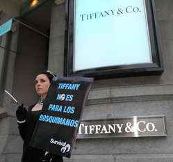 Manifestante disfrazada de Audrey Hepburn con pancarta de protesta ante la tienda de Tiffany en Madrid