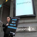 Manifestante disfrazada de Audrey Hepburn con pancarta de protesta ante la tienda de Tiffany en Madrid <small>&copy; Iñaki Luis/Survival</small>