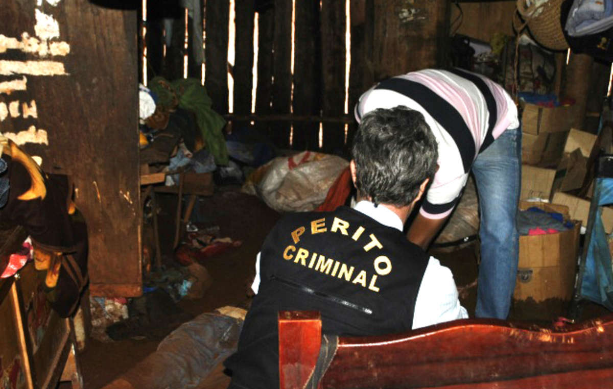 Les policiers examinent le corps d'Ambrósio à l'intérieur de sa maison.