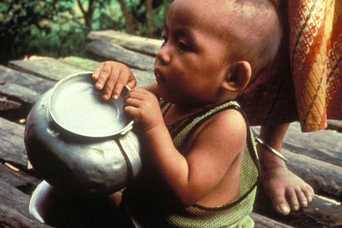 Marma baby playing at his mother's feet. In the last 60 years, the Jumma tribes have gone from being practically the sole inhabitants of the Chittagong Hill Tracts to being almost outnumbered by settlers.