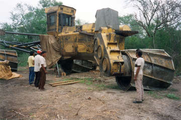 A group of Totobiegosode leaders gaze at one of the enormous bulldozers now destroying much of their hunting territory, Paraguay.