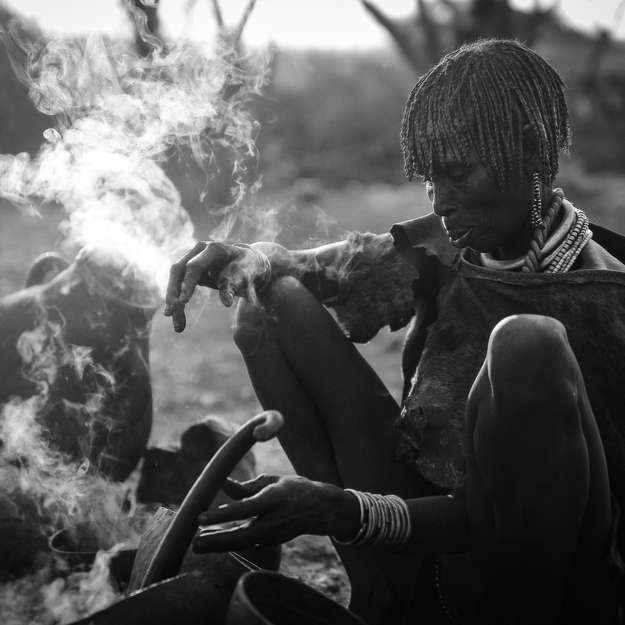 Hamar, Ethiopie, 2010

La femme d'un chef de village prépare le petit déjeuner, une calebasse de café fraîchement récolté fume derrière elle.
