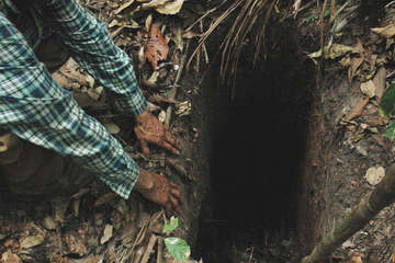 FUNAI field workers find a hole dug in the Amazon forest by the uncontacted Indian 'Last of his tribe', which he used to trap animals when hunting, Tanaru territory, Rondônia state, Brazil.
