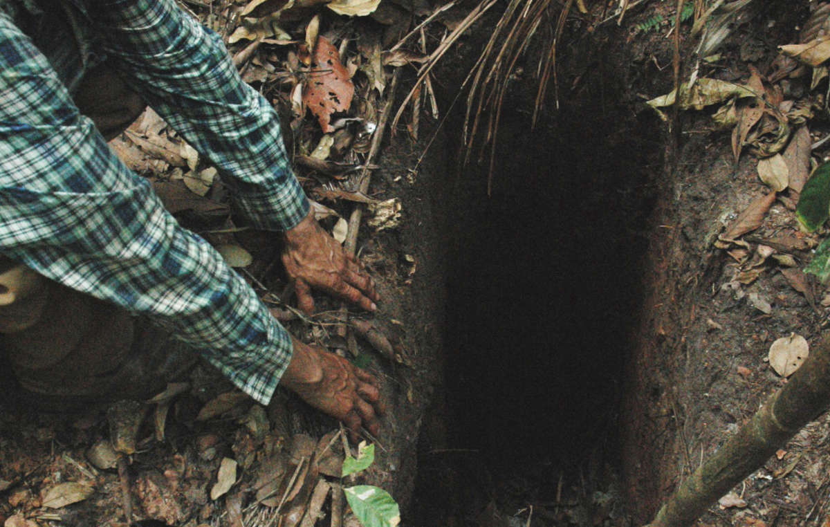 FUNAI-Mitarbeiter finden im Amazonas-Regenwald ein Loch, dass vom „Letzten seines Volkes“ gegraben wurde, um Tiere zu fangen. Tanaru-Gebiet, Rondônia, Brasilien.