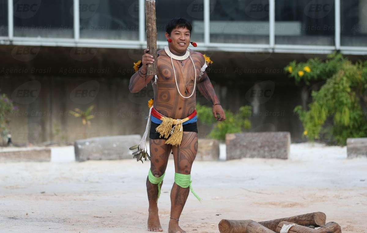 Kamukaiká Lappa brandit une réplique de la flamme olympique pour attirer l’attention sur les violations perpétrées contre les peuples autochtones du Brésil.