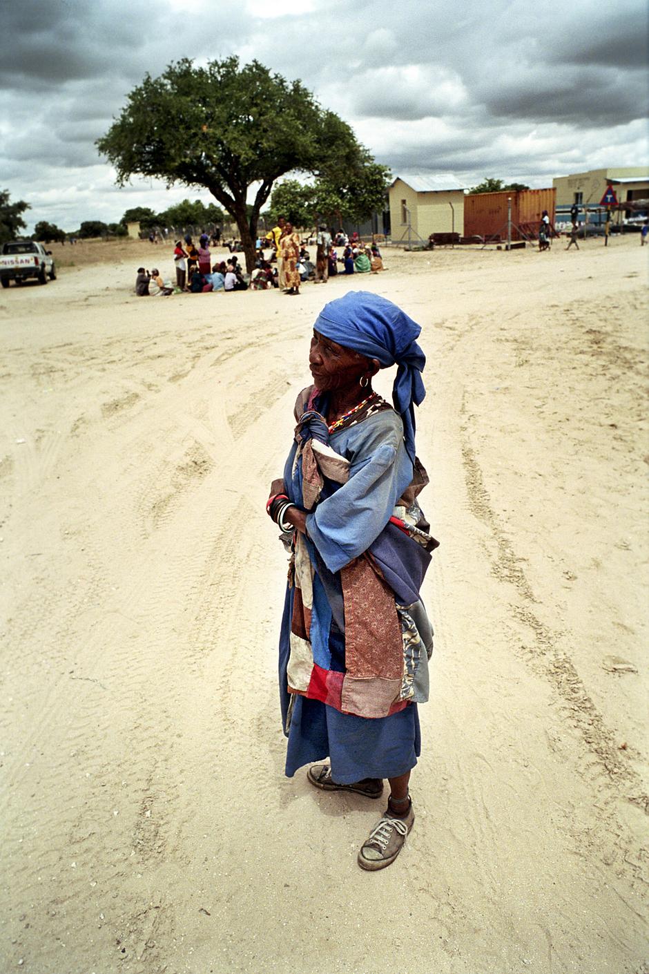 Une femme bushman à New Xade, un camp de relocalisation dans lequel les Bushmen ont été déportés au cours des dix dernières années.

Au cours des expulsions, leurs huttes traditionnelles furent détruites, les écoles et les centres de santé fermés, le puits qu’ils utilisaient détruit, la précieuse eau se perdant dans le sable du désert.

"Si j’allais voir un ministre pour lui dire ‘Quitte ton pays’, il penserait que je suis fou" a dit un Bushman.

C’est pourtant ce qui est arrivé aux gens qui vivaient autrefois entre le bassin du Zambèze et le Cap.

Le gouvernement botswanais prétend que les Bushmen doivent abandonner ce qu’il considère comme une vie misérable "parmi les animaux". Il affirme aussi que la présence des Bushmen dans la réserve n’est pas compatible avec la préservation du milieu naturel.

"Ils devraient pouvoir accéder à un statut social plus élevé" a dit le ministre des Affaires étrangères du Botswana. "Nous devrions tous être concernés par le fait qu’aucune tribu ne devrait rester dans le bush en communion avec la flore et la faune."

L’ex-président du Botswana, Festus Mogae, s’interrogeait : "Comment voulez-vous que des créatures de l’âge de pierre puissent encore exister à l’ère du numérique ?"