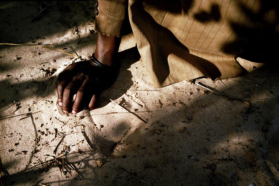 A Bushman who has just returned home to the CKGR runs the sand of the Kalahari through his fingers for the first time in five years.  

‘We were made the same as the sand, we were born here,’ he says. ‘This place is my father's father's father's land.’