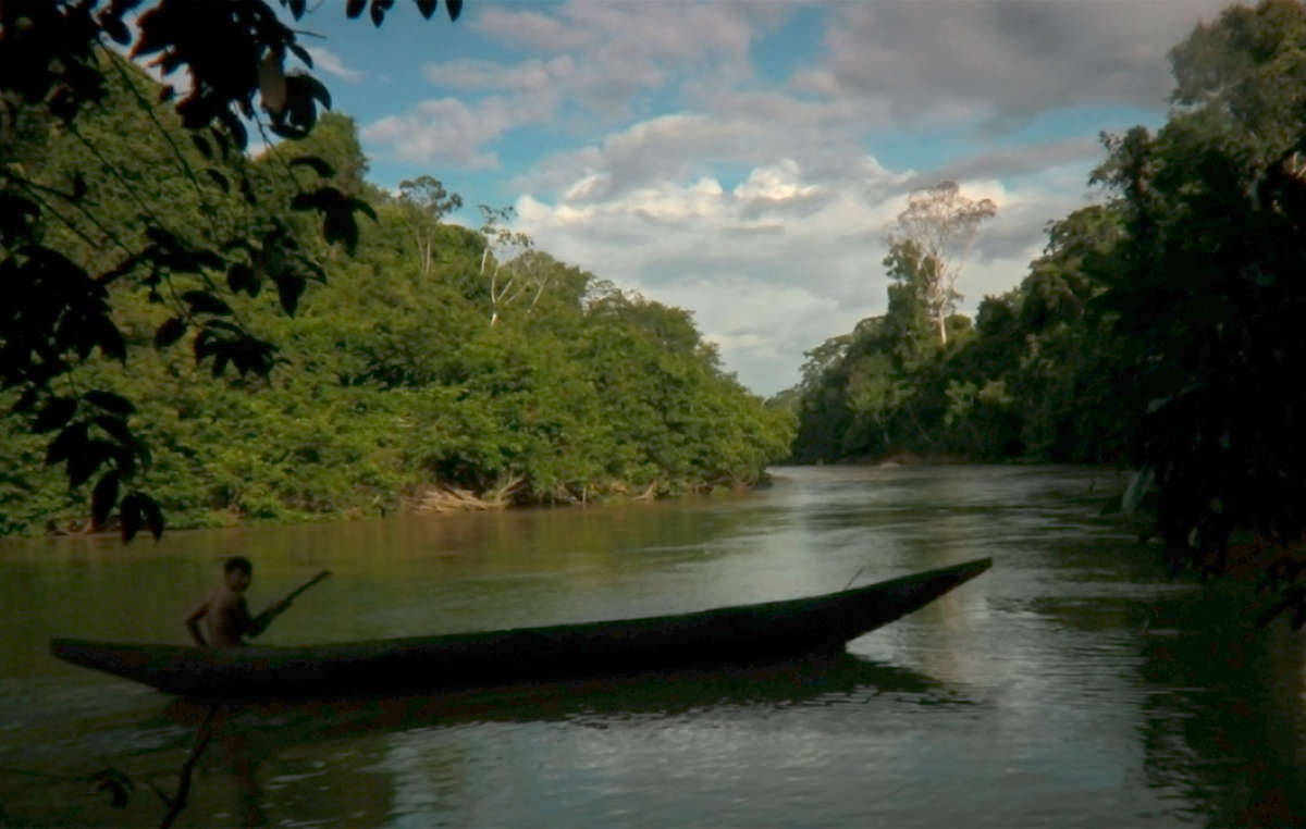 Um menino Yanomami volta de canoa para a sua aldeia na Amazônia brasileira