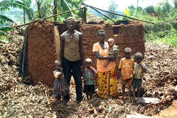 Une famille pygmée batwa devant les ruines de sa maison. Le toit a été démantelé par les autorités locales dans le cadre du programme gouvernemental visant à éliminer tous les toits en chaume du Rwanda.
