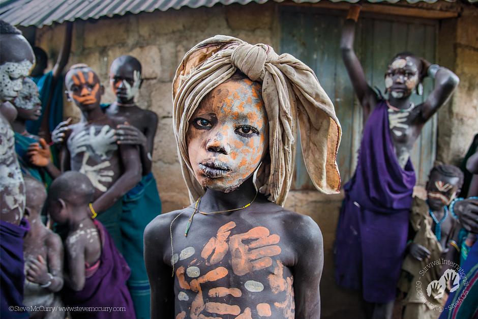 Ragazzo della tribù dei Suri. Valle dell’Omo, Etiopia, 2014. Calendario 2019 di Survival.

Da decine di migliaia di anni, gli uomini usano l'impronta della mano per lasciare un segno della propria esistenza. Le mani del logo di Survival International ci ricordano che i popoli indigeni vivono qui e ora, e che devono avere un posto nel mondo di domani come chiunque altro. Ma ci rivolgono anche un appello collettivo a sostenerli. Comprando e mostrando questo calendario, sarai parte di questo movimento mondiale. 