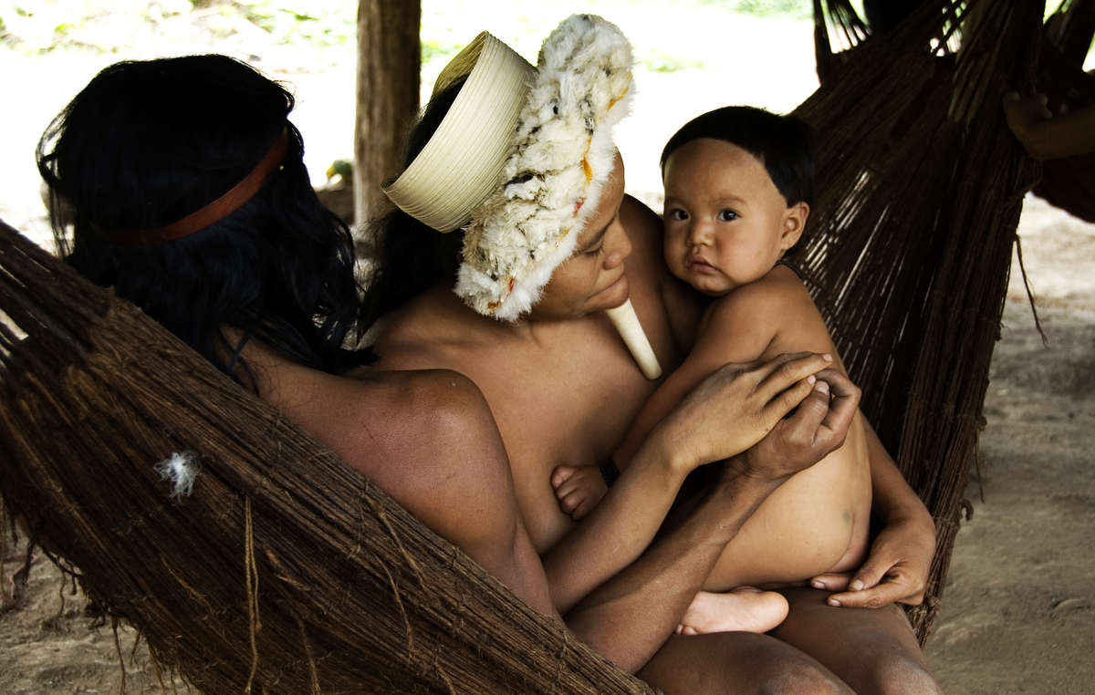 Une famille se repose dans un hamac en fibres de noyer du Brésil.