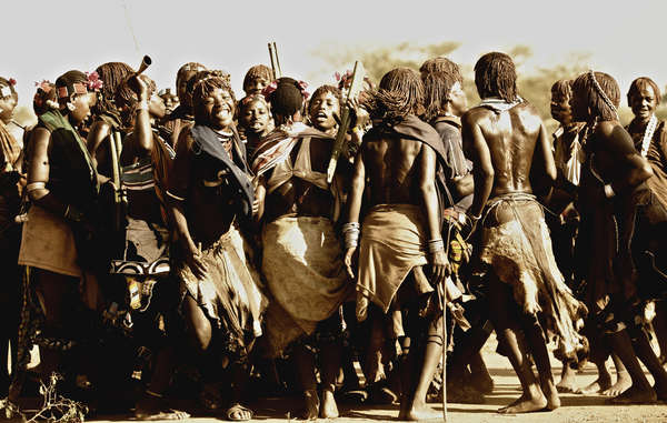 Excited Hamar women blowing their horns and shouting taunts to the Maza men who will whip them. Women regard the scars as a proof of devotion to their husbands. 