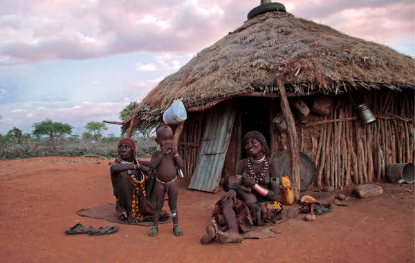 Una famiglia Hamar davanti alla sua casa, valle dell’Omo, Etiopia. La diga Gibe III distruggerà i mezzi di sussistenza del suo popolo.