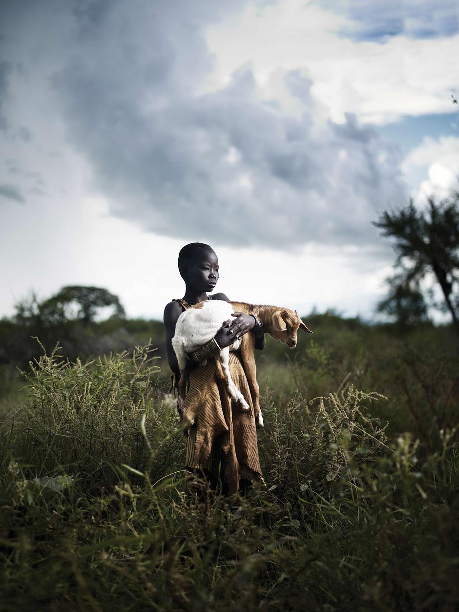 A Bodi boy in Ethiopia carries his goat; at a young age, they also learn poems that they sing to their favorite cows.

_The first, and completely dependent, stage of life does not last long for most tribal children_, says Stephen Corry.  _By the age of four or five, children start to join adult activities: boys hunt or tend livestock, girls look after smaller children and help at the hearth or in food gathering_.

In Malaysia, Penan children help to build homes from tree saplings; beneath the blue-green surface of the Andaman Sea, Moken children learn to catch dugong and sea-cucumber with long harpoons; on the grasslands of Mongolia, Tsaatan children's parents teach them the ancient herding skills of corralling reindeer.

