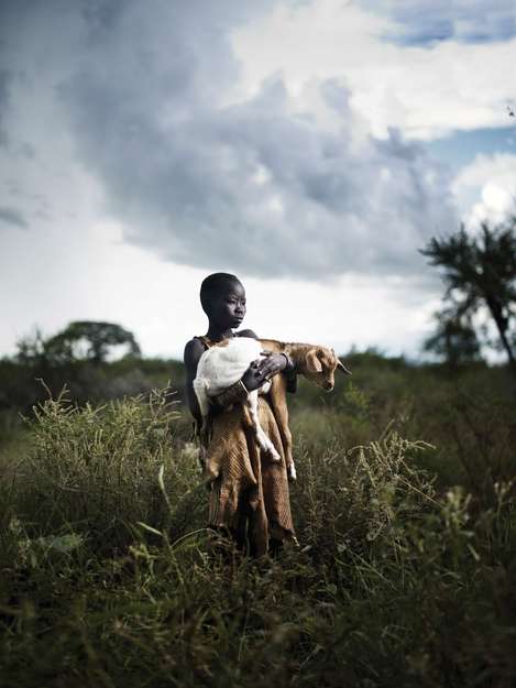 Unter einem grauen Himmel, inmitten der grünen und stacheligen Pflanzen des äthiopischen Omo-Tals, trägt ein Junge des Bodi-Volkes seine Ziege.

Die Völker, die am Unterlauf des Omo-Flusses leben, haben landwirtschaftliche Methoden entwickelt, die genau auf die Überschwemmungszyklen des Omo angepasst sind. Sie nutzen den reichhaltigen Silt, den das zurückweichende Wasser am Flussufer hinterlässt, um eine Vielfalt von Pflanzen anzubauen.

Jungen lernen das Viehzüchten von klein auf. Bodi-Kinder lernen beispielsweise ihren liebsten Kühen Gedichte vorzusingen. Mädchen helfen meist beim Feldbau.

Der lebensspendende Fluss ist heute wegen staatlich genehmigten Entwicklungsmaßnahmen, darunter Afrikas höchstes Wasserkraftwerk, in Gefahr. Durch dieses Projekt werden die Völker den Silt für ihren Anbau verlieren.