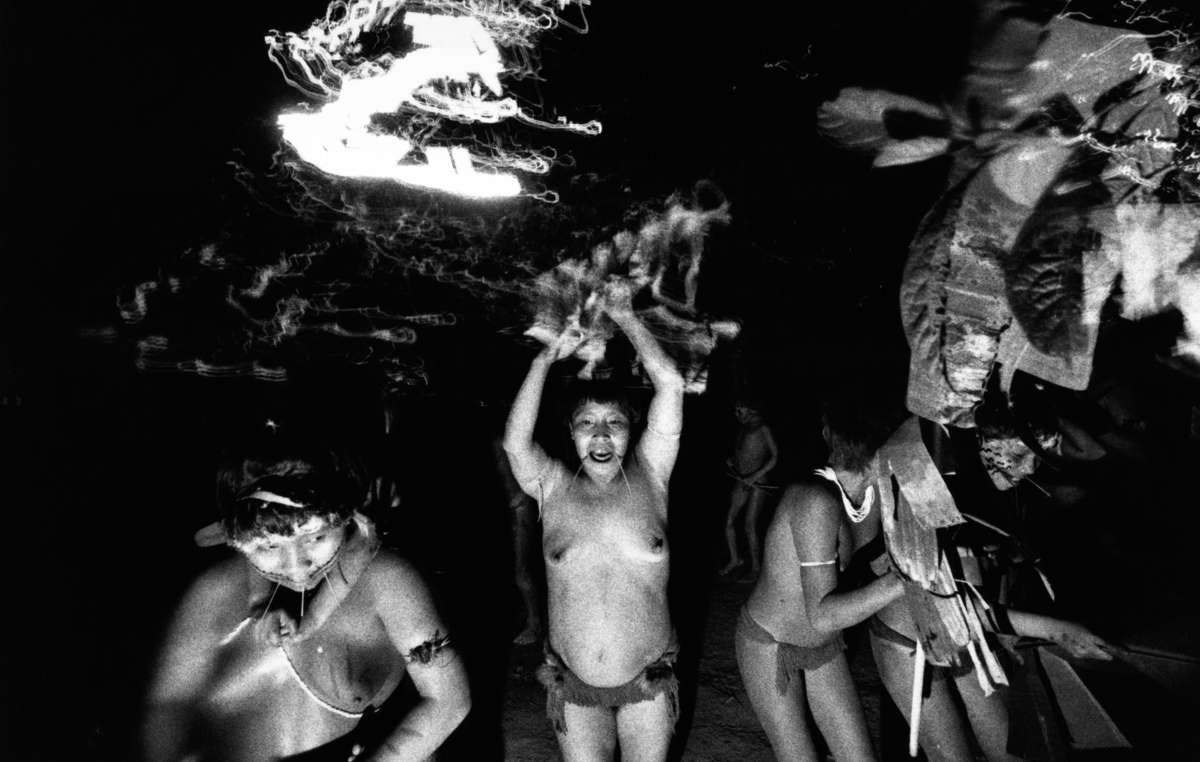 Yanomami-Frauen tanzen. Jedes Lebewesen, jeder Stein, jeder Baum und jeder Berg besitzt einen Geist. Manchmal sind diese bösartig und die Yanomami glauben, dass sie Krankheiten hervorrufen. Yanomami-Schamanen kontrollieren diese Geister, indem sie ein Pulver namens Yakoana inhalieren, das Halluzinationen hervorruft.