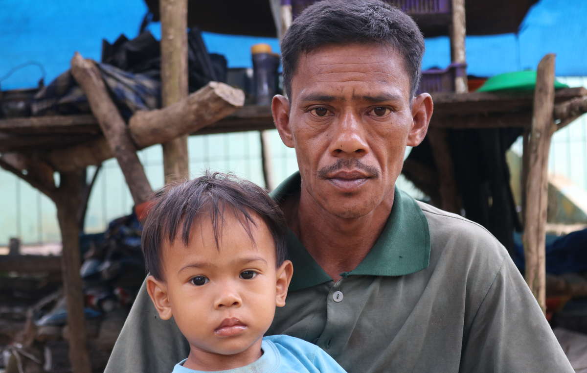 Selora with his son Rapa. Their forest has been destroyed and turned into an oil palm plantation.
