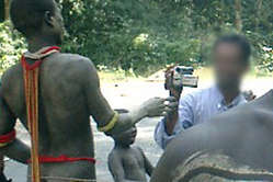 Un touriste filme un Jarawa sur la route principale des îles Andaman.