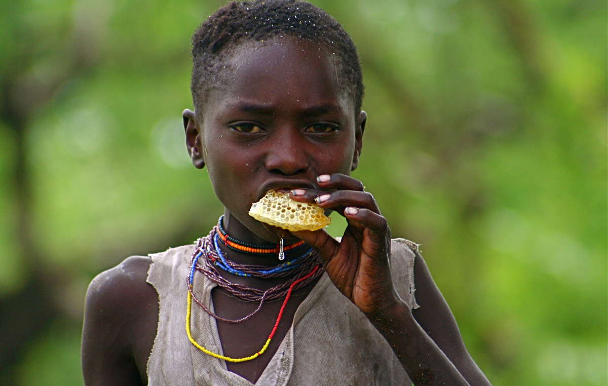 Las imágenes tienen el poder de capturar momentos íntimos de las vidas indígenas, como el de esta niña hadza comiendo miel en Tanzania.