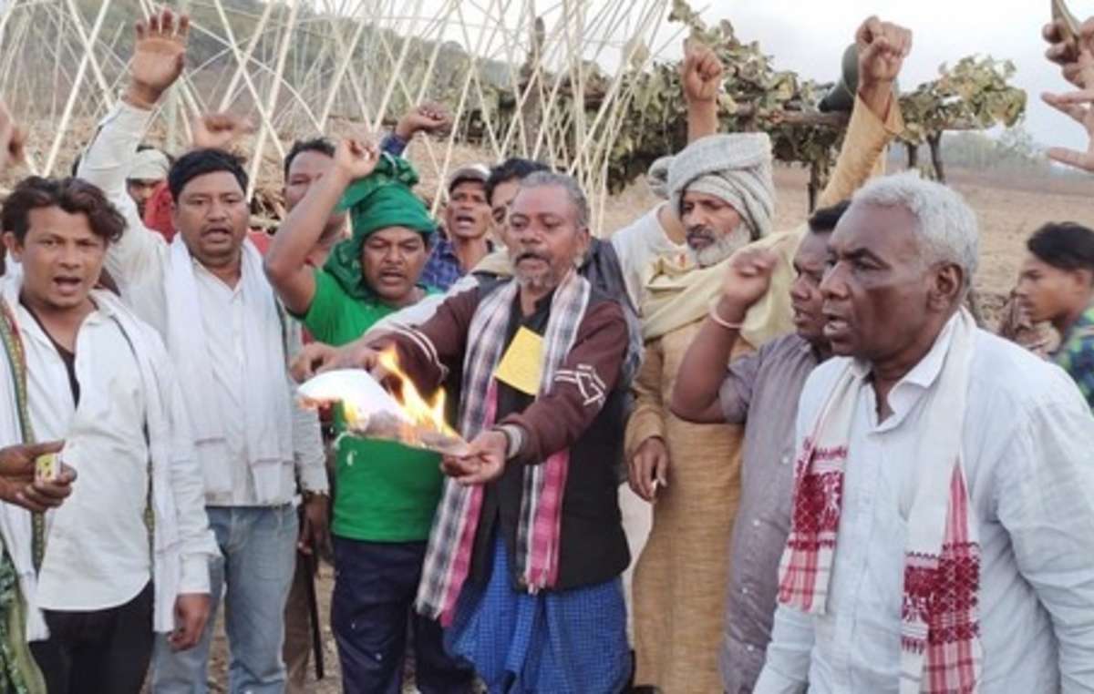 Adivasis burning copies of the farm laws in India.