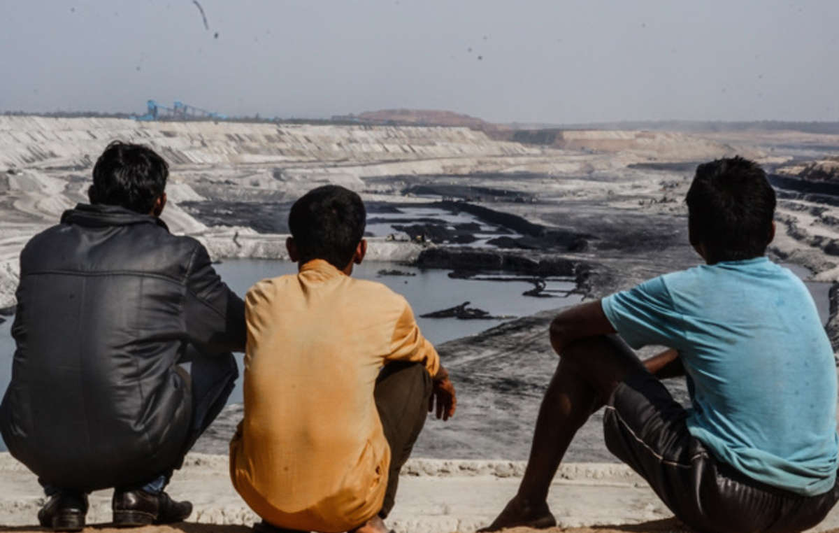 Hombres adivasis miran hacia la inmensa mina de carbón de PEKB que ha destruido gran parte de su tierra ancestral (bosque de Hasdeo, Chhattisgarh).