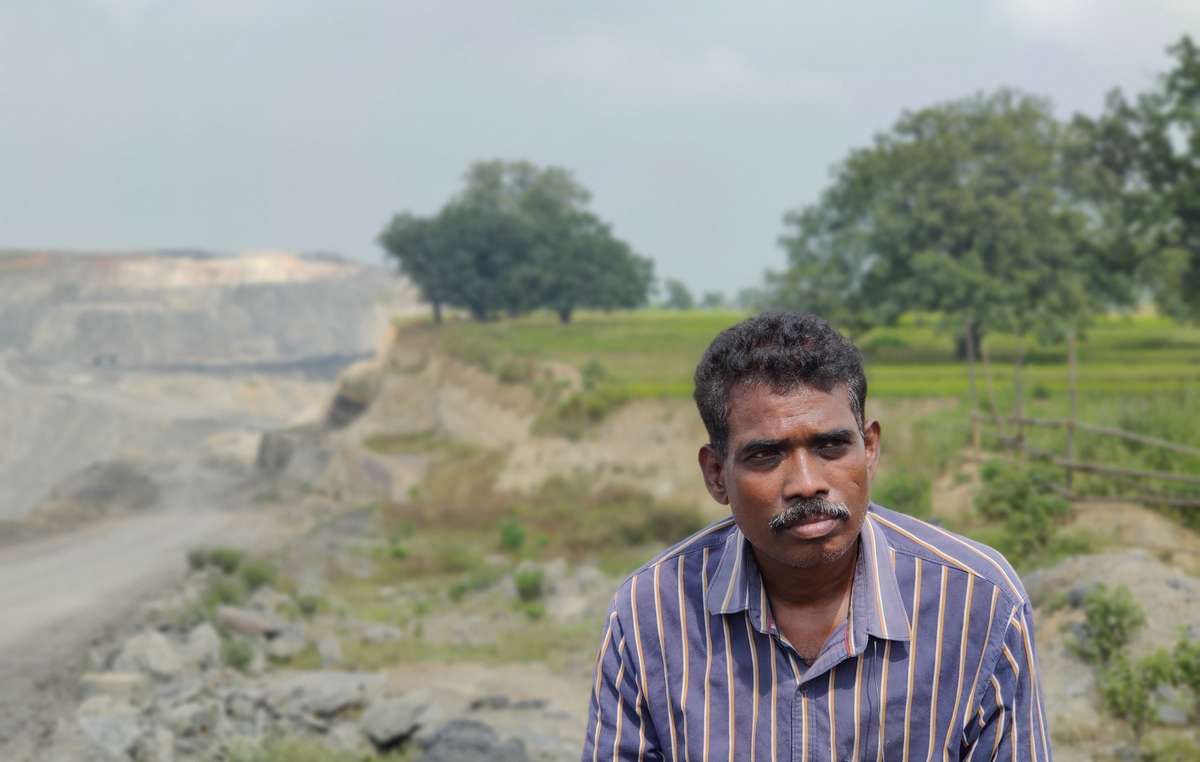 Phillip, un activista oraon. La tierra de su pueblo (al fondo) ha sido seccionada en dos por una gigantesca mina de carbón.