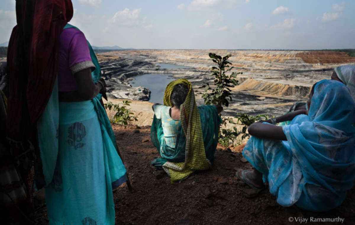 Des femmes regardent la mine PEKB qui remplace désormais leurs forêts ancestrales et leurs sites sacrés. (Forêt de Hasdeo, Chhattisgarh)