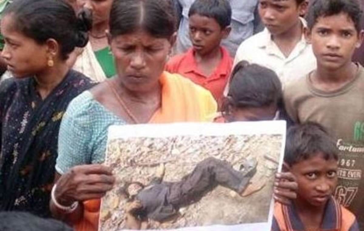 Madkam Lakshmi holds a photo that the police released of her daughter, Hidme. The police claim she was killed in a gun battle. Lakshmi saw them drag her daughter, dressed in a sari, out of their house.