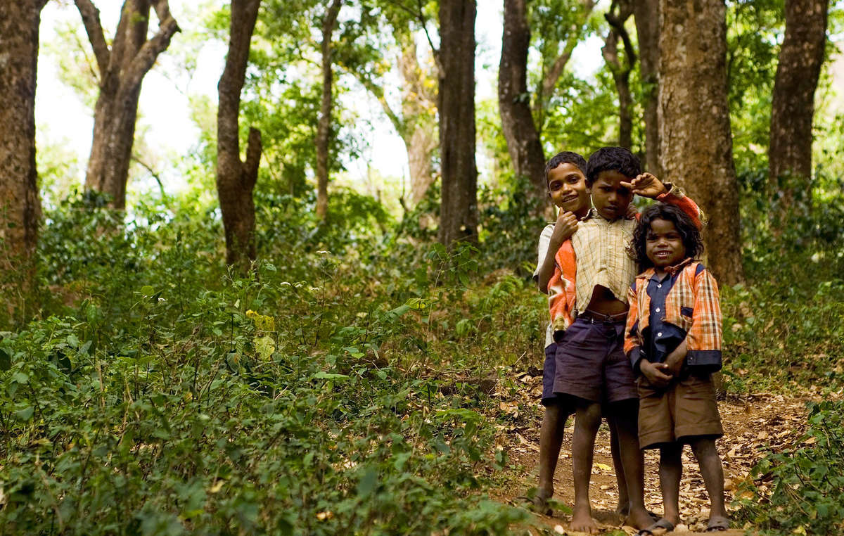 Soliga-Jungen spielen auf einer Lichtung im Rangaswamy Temple Schutzgebiet