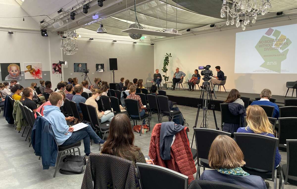 Teilnehmende an der Konferenz „Keine Biodiversität ohne menschliche Vielfalt“ hören Expert*innen und indigenen Stimmen zu, die über von Deutschland unterstützte Naturschutzprojekte im Globalen Süden berichten.