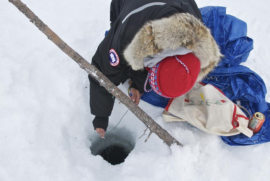 Innu women drilled holes through thick ice, to fish for lake trout.


