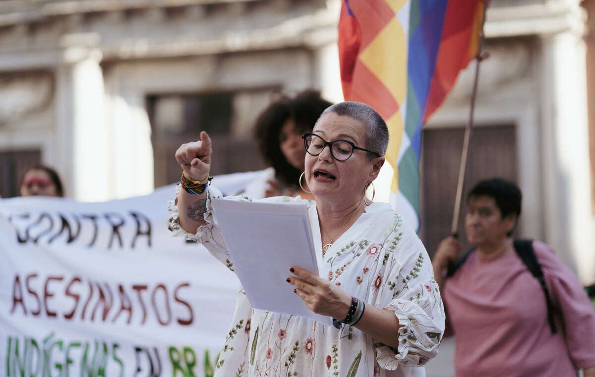 A deputada hispano-brasileira Maria Dantas discursa em protesto em Madri, Espanha, durante a visita do presidente da FUNAI Marcelo Xavier.