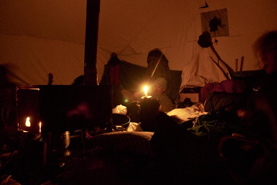 Inside a traditional Innu tent, a sheet-metal stove is stoked throughout the night with dry juniper wood.

Spruce boughs, arranged in an intricate overlapping pattern on the floor, provide insulation against the cold. 

