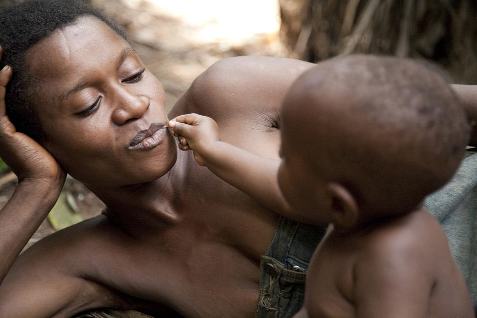 In the marsh forests and riverine valleys of the Congo Basin in Africa, an Aka 'pygmy' child plays with his mother.

Ba'Aka infants - like many other tribal babies - are held almost constantly throughout the day.