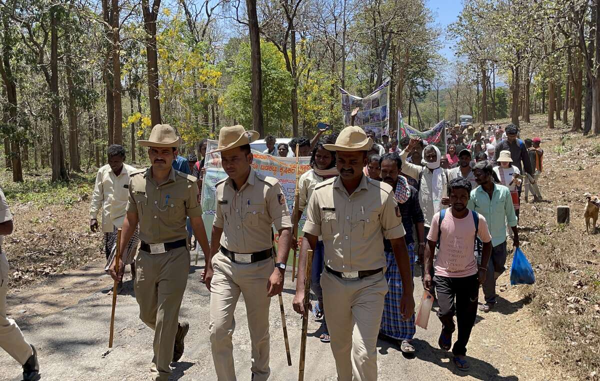 Agentes de policía 'escoltan' a indígenas de Áreas Protegidas de toda la India mientras se dirigen a la oficina del Departamento Forestal en la Reserva de Tigres de Nagarhole para iniciar una protesta indefinida para exigir el fin de las expulsiones y los abusos en nombre de la conservación de la naturaleza.