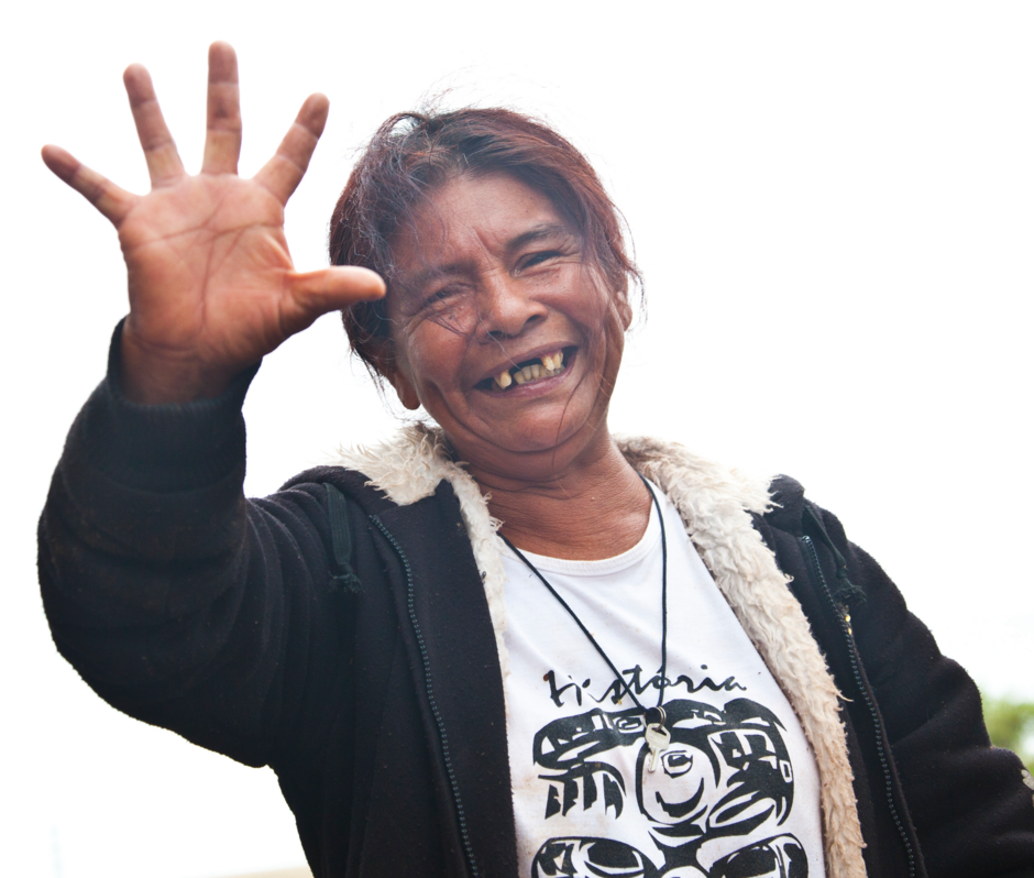 Damiana Cavanha, the leader of the Guarani community of Apy Ka'y, smiles holding up one open hand.