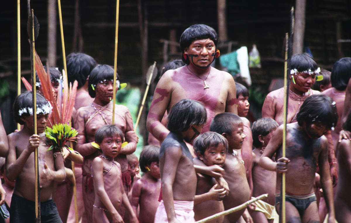 Davi Kopenawa cercada por crianças na aldeia Demini, Brasil